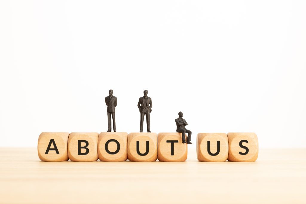 about us phrase on wooden blocks and figurines. copy space